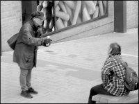 Standing man talking to seated woman Cheeke St Exeter A65 DSC00643.JPG